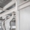 Aplicación de pintura ignífuga sobre estructura y muro para protección pasiva contra incendios.